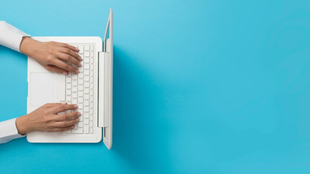 Overhead view of hands typing on a laptop keyboard, representing accounting automation with BlackLine software.