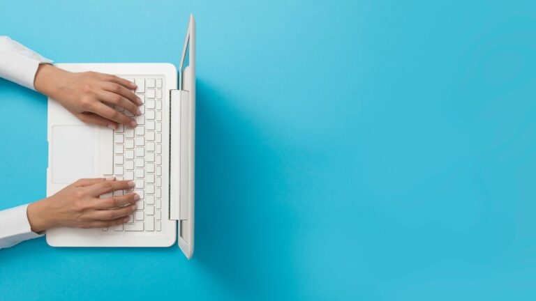 Overhead view of hands typing on a laptop keyboard, representing accounting automation with BlackLine software.