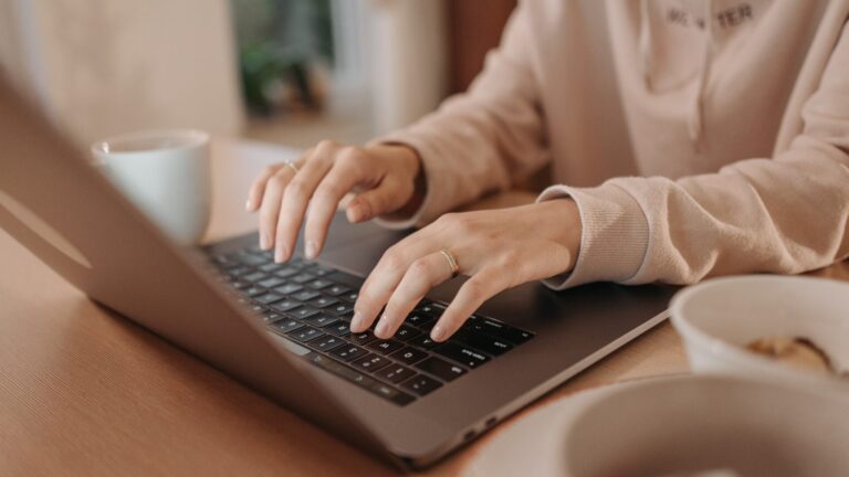 Woman sitting at a desk, working on a laptop to streamline accounting tasks with BlackLine’s financial close automation